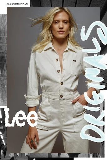 A woman in a jumpsuit poses for a Lee Originals fashion advertisement with overlaid text and brand logo on a grey studio backdrop.