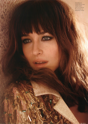 Close-up portrait of a woman with long brown hair and bangs wearing an embellished fringed coat with makeup by Lisa Houghton.