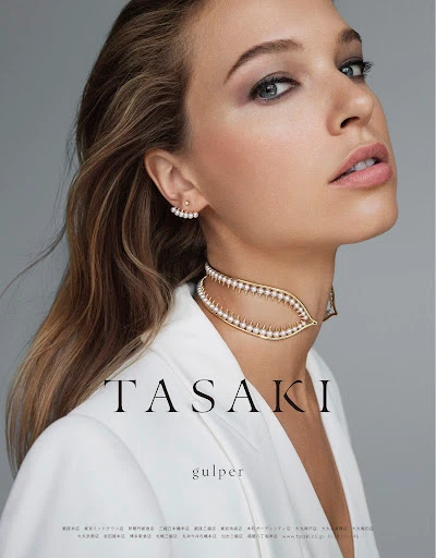 Close-up portrait of a woman wearing a gold pearl choker necklace and white jacket with makeup by Lisa Houghton.