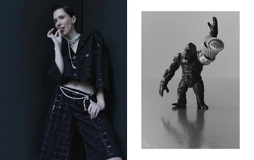 Fashion editorial shot of a woman in a black beaded suit and a toy gorilla adorned with rings against a black and gray background.