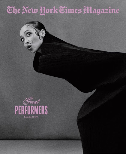 The New York Times Magazine cover featuring a woman with dark hair and dramatic makeup, posing in a black coat against a gray background.