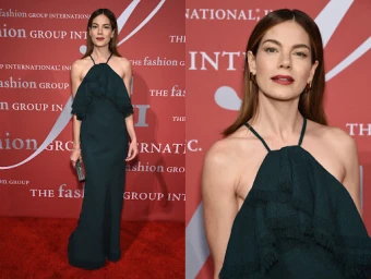 Michelle Monaghan wearing a dark green halter neck dress with fringe detail on a red carpet with branded backdrop