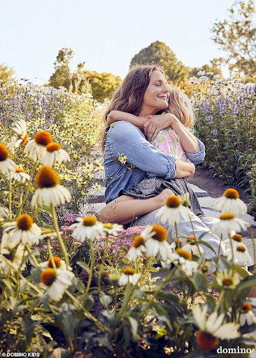 A mother and child embracing in a field of colorful wildflowers, showcasing a heartwarming moment in a natural setting on a sunny day.