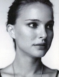 Close up portrait of a woman looking to the side against a plain white background in black and white