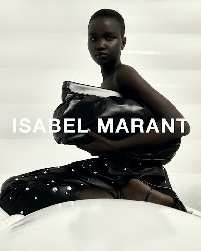 Black model holding a large leather clutch in a studio with white padded backdrop and bold text overlaid