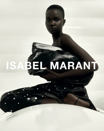 Black model holding a large leather clutch in a studio with white padded backdrop and bold text overlaid