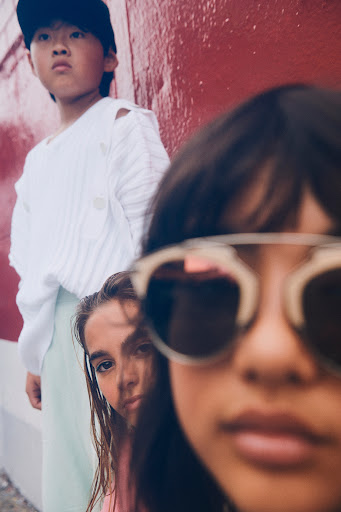 Three young models posing outdoors with make-up by Thora, featuring sunglasses in Los Angeles