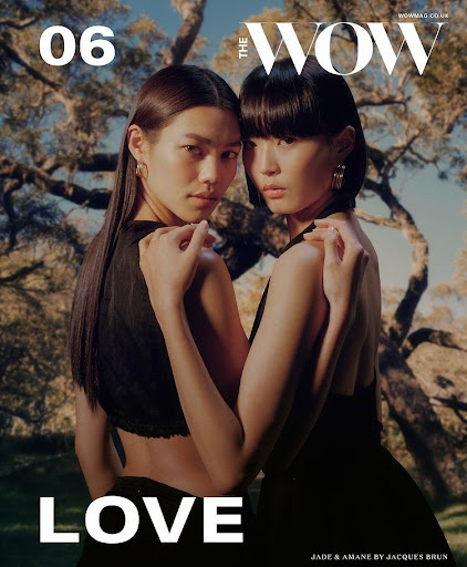 Two Asian women pose together in a magazine cover, wearing black dresses, with an outdoor tree-filled background and the word 'LOVE' visible.