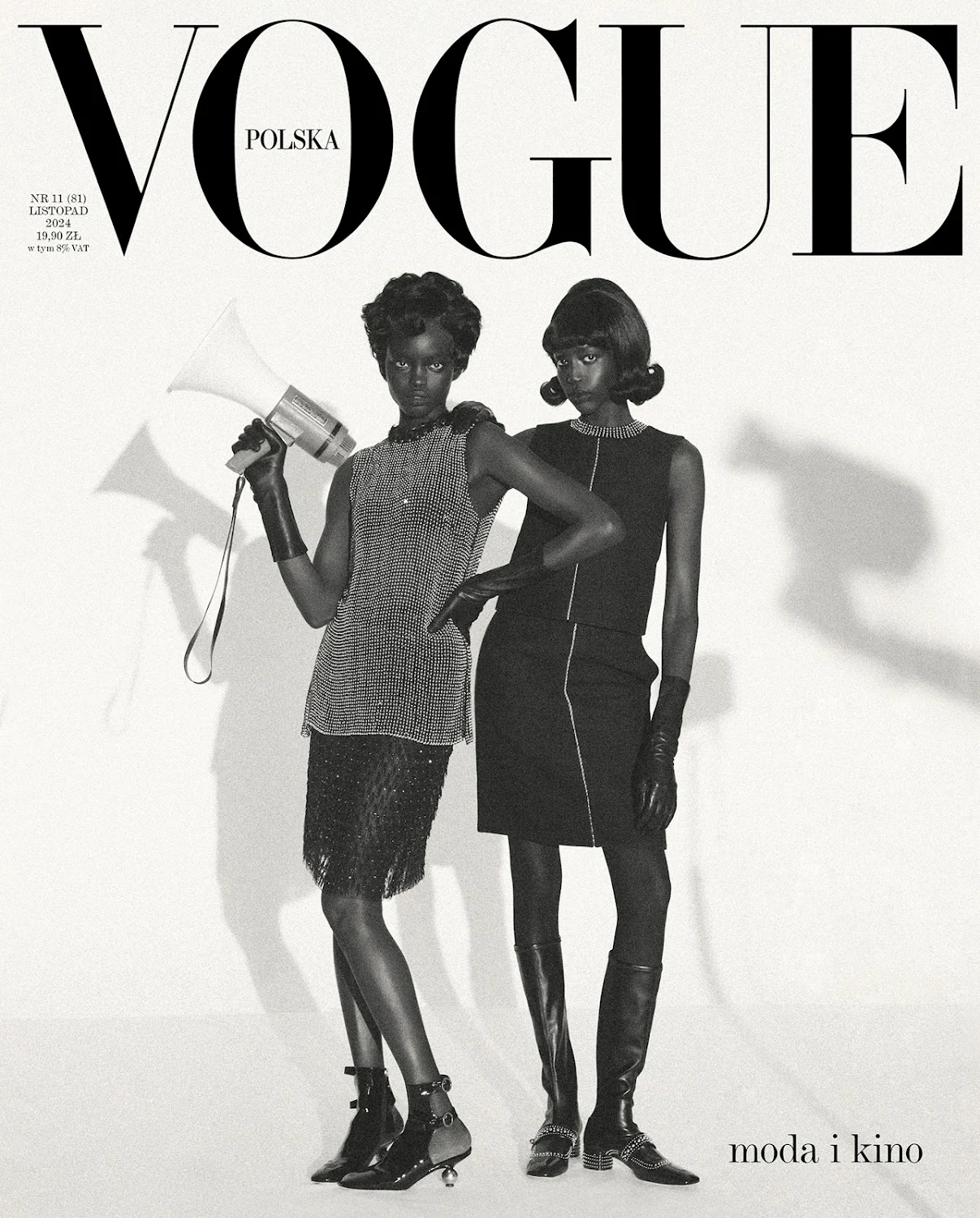 Two models on a Vogue Polska cover in black and white, one holding a megaphone, wearing stylish vintage-inspired dresses and accessories.