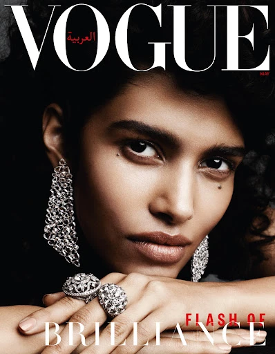 Vogue Arabia cover featuring a close-up portrait of a striking woman with ornate silver jewelry against a dark background.  