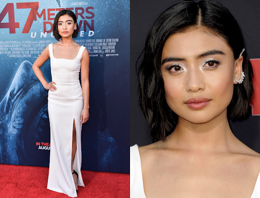 Actress posing on red carpet in white gown with slit. Close up of face with silver eyeshadow and hair accessories. 