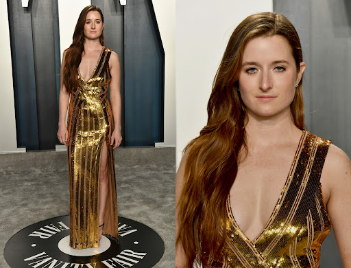 Elegant woman in a gold sequin gown with a thigh-high slit posing at an event. The backdrop features the Vanity Fair logo.