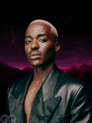 Portrait of Black male adult in black leather jacket, styled with short bleached hair, against a digital landscape background. GQ logo visible.