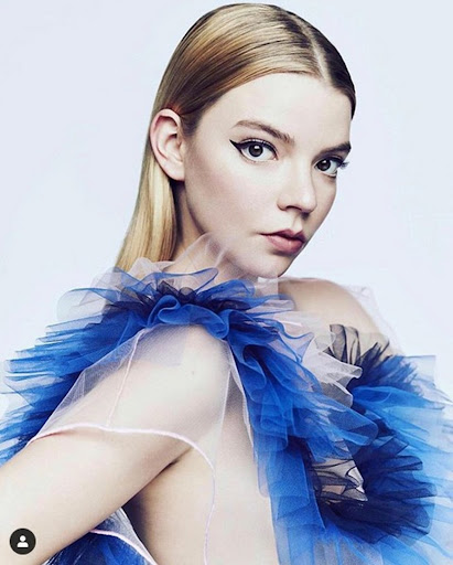 Portrait of a blonde woman with blue tulle collar against a white backdrop, beauty and fashion photography, close-up shot.