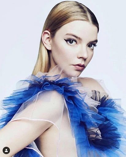 Portrait of a blonde woman with blue tulle collar against a white backdrop, beauty and fashion photography, close-up shot.