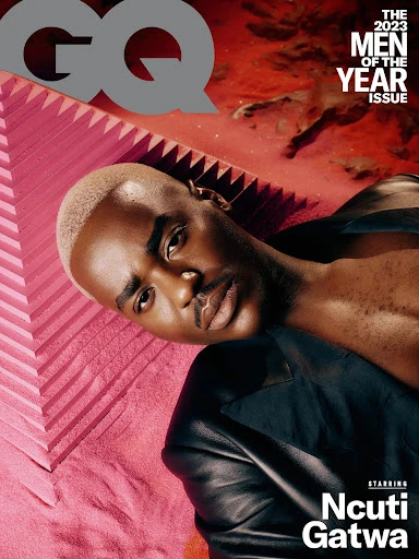 Ncuti Gatwa poses on a pink surface in a low angle shot for the cover of GQ Magazine's 'Men of the Year' issue, wearing a black jacket.