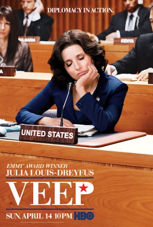 Poster for the TV show Veep featuring Julia Louis-Dreyfus as Selina Meyer, seated at a table with a United States placard.