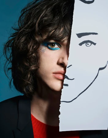 Close-up fashion portrait of a young adult with vibrant eye makeup and textured hair, paired with a striking line-art drawing.