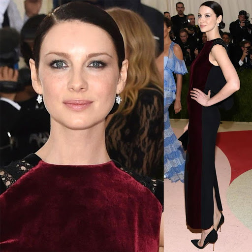 Caitriona Balfe poses in a black gown with burgundy velvet accents on a red carpet, at a celebrity event with onlookers.