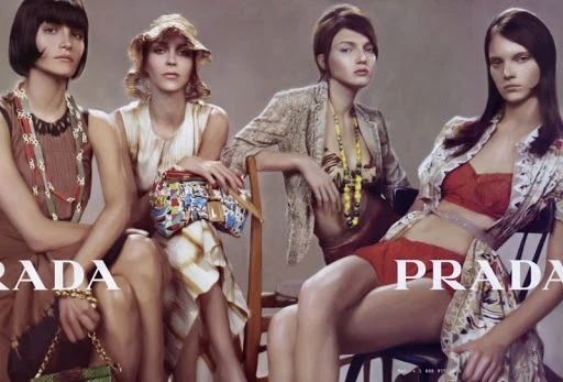 Fashion editorial featuring four diverse female models in vintage-inspired clothing and accessories, posing against a neutral studio backdrop.