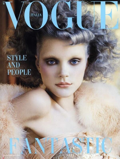 Close-up portrait of a woman with voluminous grey hair and feathered furry garment for Vogue Italia editorial