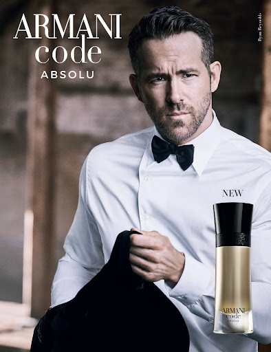 Ryan Reynolds stars in an Armani Code Absolu perfume ad, wearing a classic black bow tie and holding a black suit jacket.