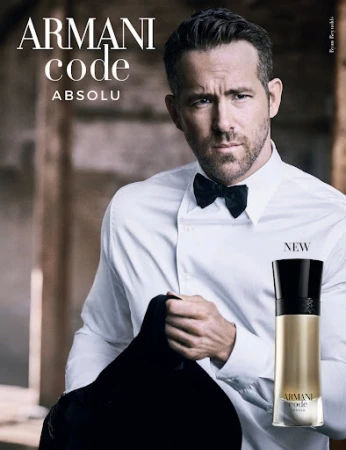 Ryan Reynolds stars in an Armani Code Absolu perfume ad, wearing a classic black bow tie and holding a black suit jacket.