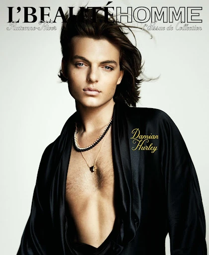 Magazine cover featuring adult male with dark hair wearing a black robe, a gold necklace, and beaded necklace with a light background.