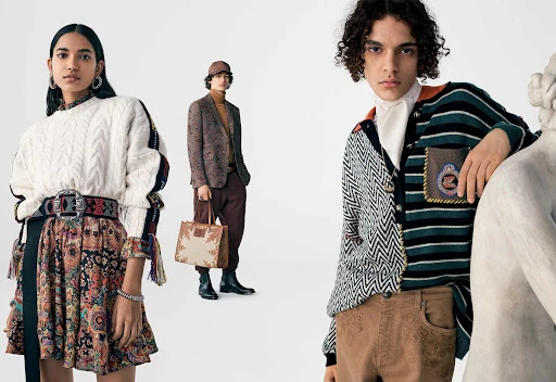 Group of three fashion models posing against a white background wearing patterned autumn apparel and carrying a tote bag