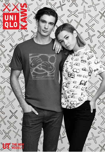 A man and a woman pose next to each other, both wearing graphic t-shirts in a monochromatic studio shot with a patterned background.