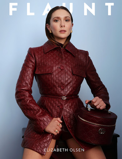 Elizabeth Olsen poses in a textured maroon jacket with a matching Gucci purse in a studio shot for Flaunt magazine.