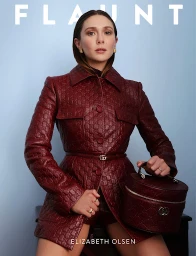 Elizabeth Olsen in a burgundy patterned leather jacket and handbag against a light blue backdrop