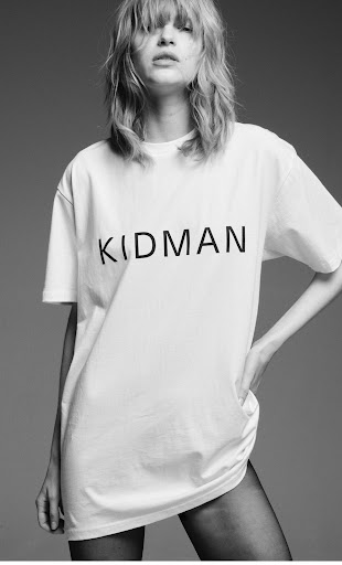 Model wearing a white t-shirt with Kidman text and dark tights against a grey background