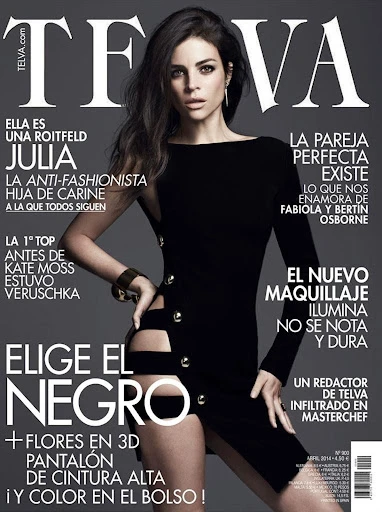 A fashion magazine cover featuring a brunette adult woman in a black dress with cutouts, posing against a dark grey gradient background.