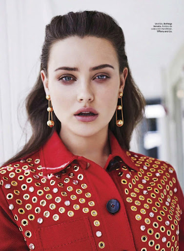Portrait of a woman wearing a red jacket embellished with gold hardware and drop earrings