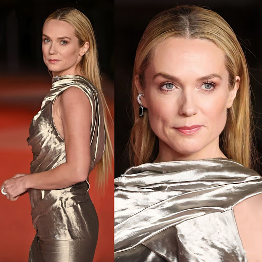 Close-up studio shot of a blonde woman in a draped, metallic bronze dress. Light skin, bright eyes, straight blonde hair, evening dress.