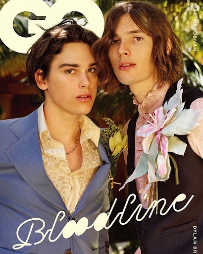 GQ magazine cover featuring Dylan and Paris Brosnan in formal attire, accessorized with floral arrangements in an outdoor setting.