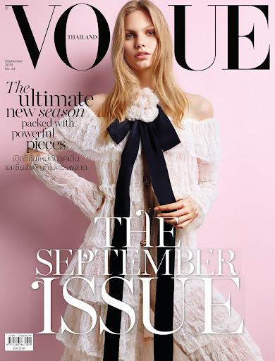 Model in off-white lace dress with black bow against pink background