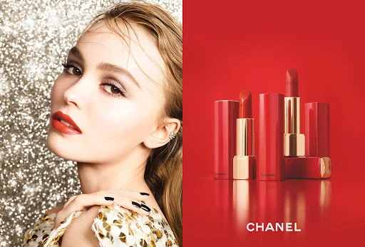 Cosmetics ad with fair-skinned adult female model wearing red lipstick, a sequin dress, and showcasing Chanel lipsticks in matching red hues.