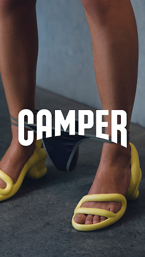 This is a vertically-oriented fashion shot featuring the legs of a human wearing yellow sandals, with black underwear suspended between their legs.