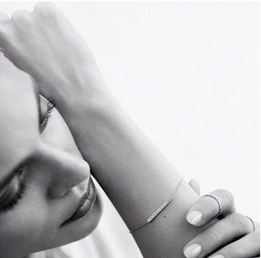 Close-up portrait of a woman with manicured nails resting her arm near her face, captured by nail artist Julie Villanova.