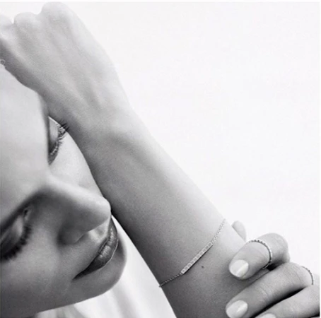 Close-up portrait of a woman with manicured nails resting her arm near her face, captured by nail artist Julie Villanova.