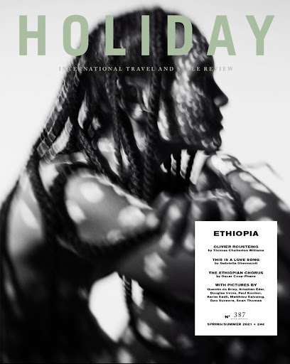 Black and white portrait of a person with braided hair patterned by dappled light shadows for a magazine cover.