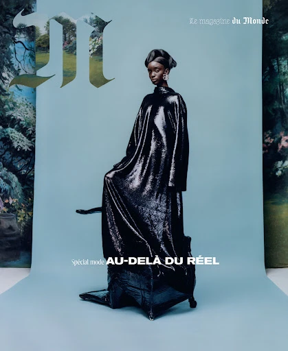 A fashion editorial magazine cover features a Black model in a shimmering black gown against a light blue backdrop with floral elements.