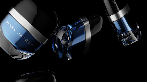 Still life of three Marc Jacobs men's fragrance bottles in dark blue, black, and silver tones against a black backdrop with reflective surface.