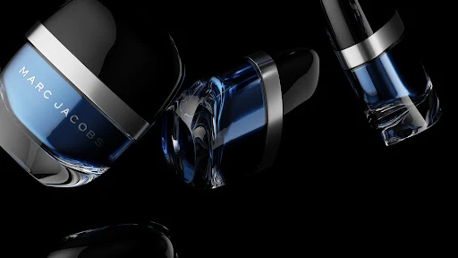 Still life of three Marc Jacobs men's fragrance bottles in dark blue, black, and silver tones against a black backdrop with reflective surface.