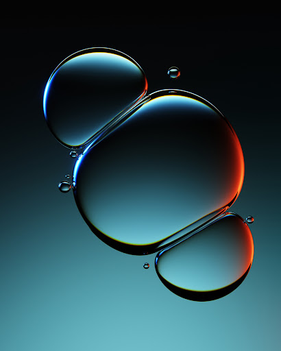 Abstract art: Three transparent water droplets suspended in gradient blue light create a visually arresting and minimalist composition.