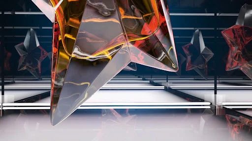 Abstract shot of transparent star objects with orange and red hues, hanging in an indoor setting with dark blue walls and white floors.