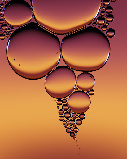 Close-up abstract image of vibrant, translucent liquid spheres in varying sizes, creating a captivating gradient background texture.