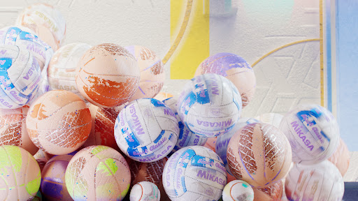 Pile of Mikasa Classic volleyballs in a close-up shot against a textured white and yellow background.